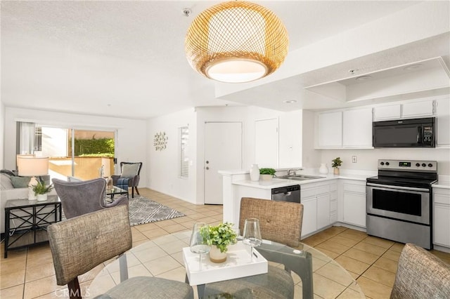 kitchen with appliances with stainless steel finishes, light tile patterned floors, light countertops, and white cabinetry