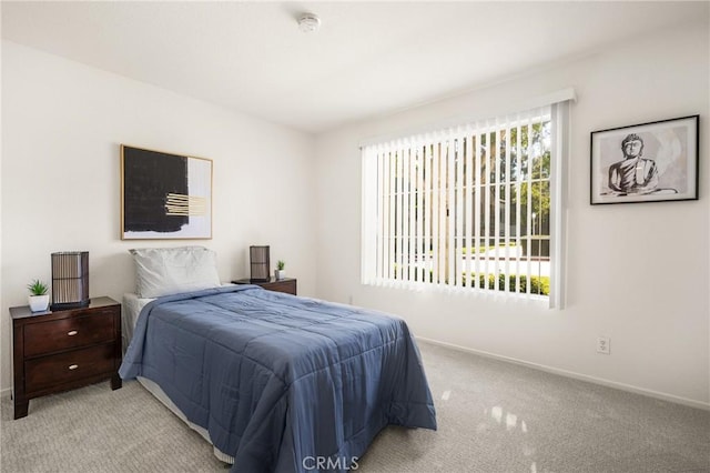 bedroom featuring light carpet and baseboards