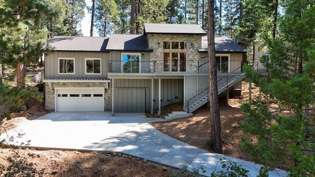 view of front of property featuring a balcony, cooling unit, and a garage