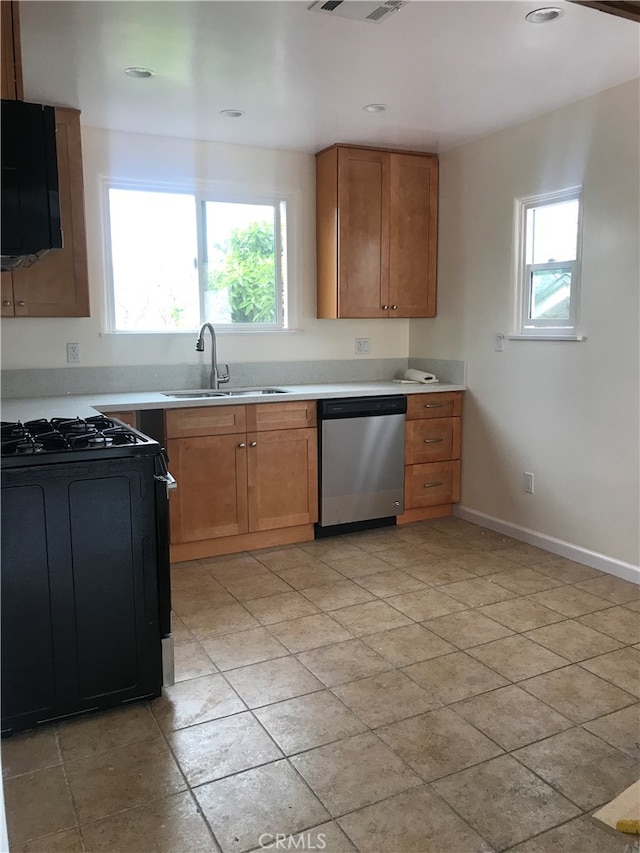 kitchen featuring sink, black range, dishwasher, and a wealth of natural light