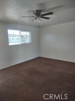 empty room with dark carpet and ceiling fan