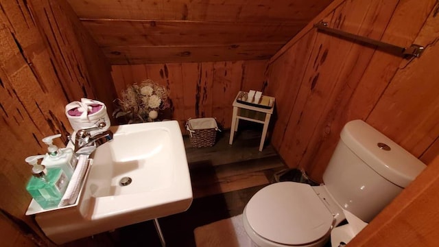 bathroom with wooden ceiling, wooden walls, and toilet