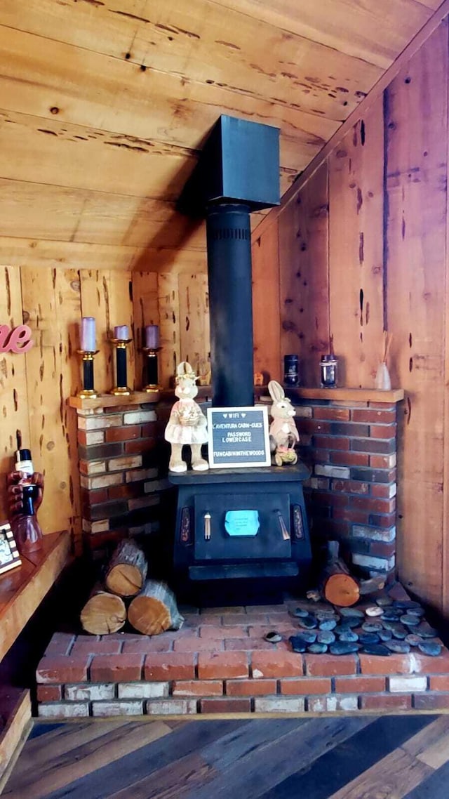 bar with wood-type flooring, a wood stove, wooden ceiling, and wooden walls