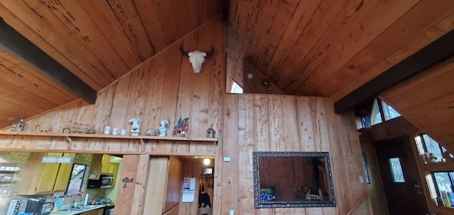 interior details featuring sink, wooden walls, range with electric cooktop, wooden ceiling, and beamed ceiling