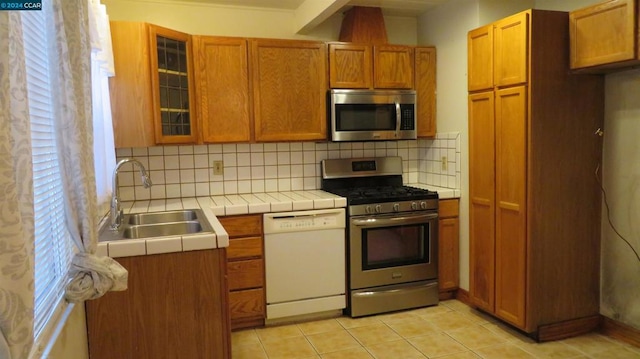 kitchen with backsplash, sink, plenty of natural light, and appliances with stainless steel finishes