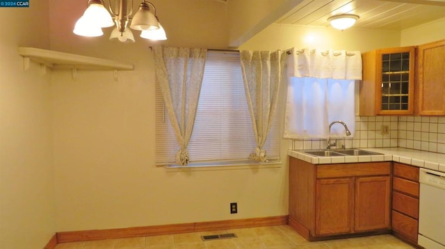 kitchen featuring decorative backsplash, sink, decorative light fixtures, tile countertops, and dishwasher