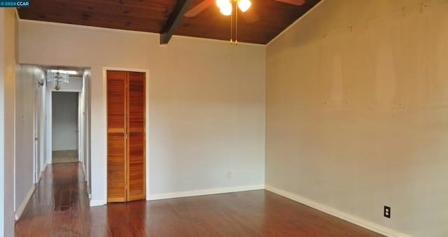 empty room with lofted ceiling with beams, ceiling fan, dark wood-type flooring, and wood ceiling