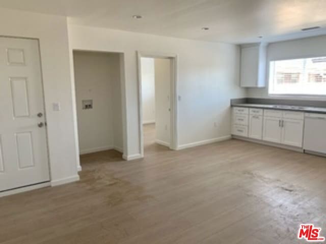 kitchen featuring dishwasher, light wood-type flooring, and white cabinetry