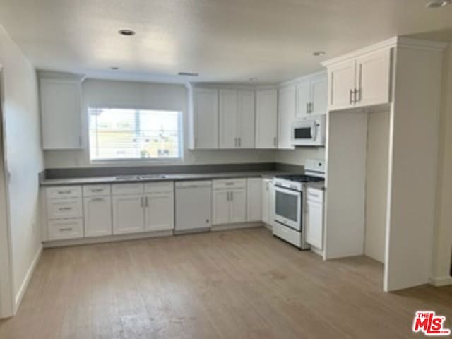 kitchen featuring light wood-type flooring, white appliances, and white cabinetry