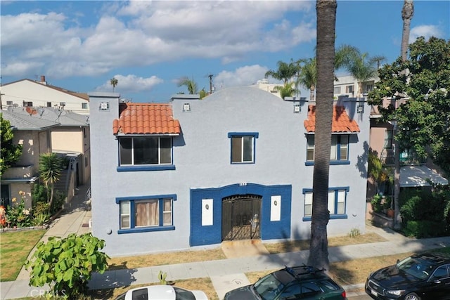 1135 E 3rd St, Long Beach, CA 90802 - rear view of property featuring a tile roof, stucco siding, a residential view, and uncovered parking