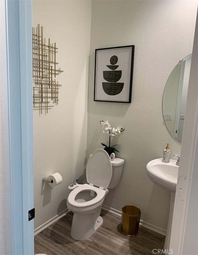 bathroom with hardwood / wood-style flooring and toilet