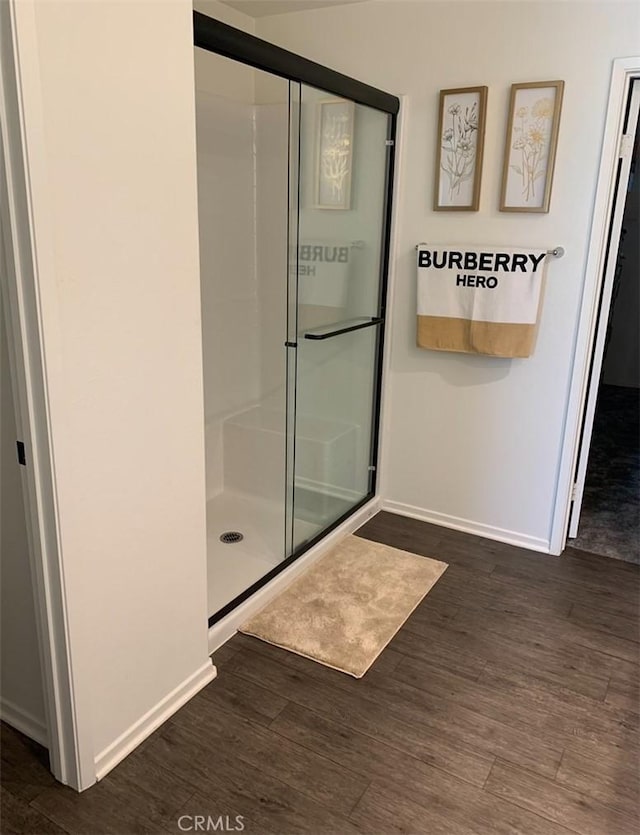 bathroom with a shower with door and hardwood / wood-style flooring