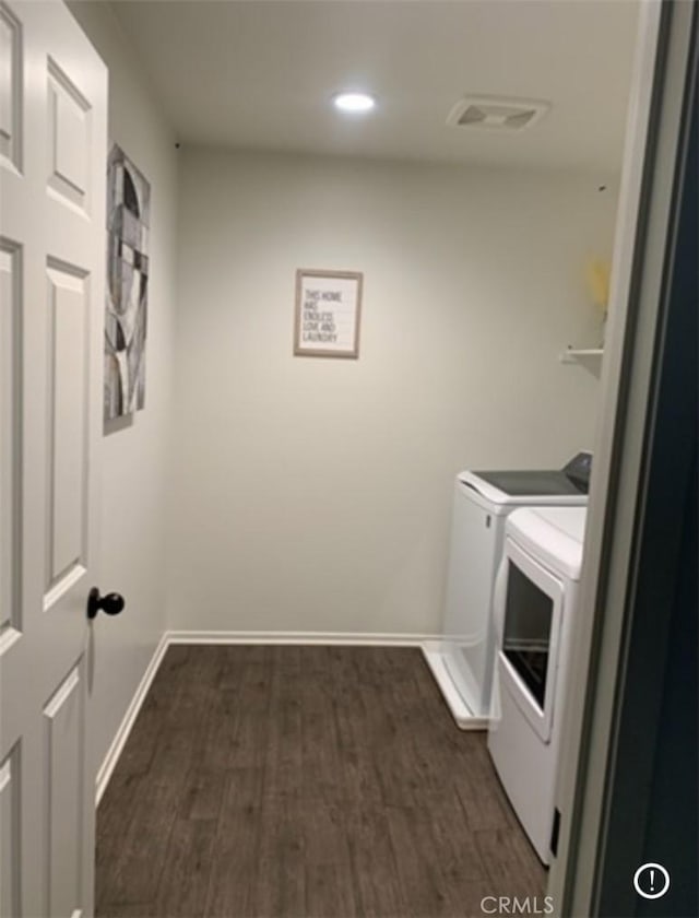 clothes washing area featuring washer and dryer and dark wood-type flooring