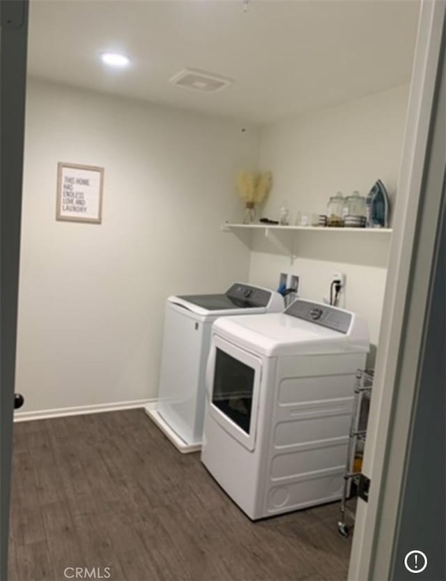 laundry area featuring washing machine and dryer and dark wood-type flooring