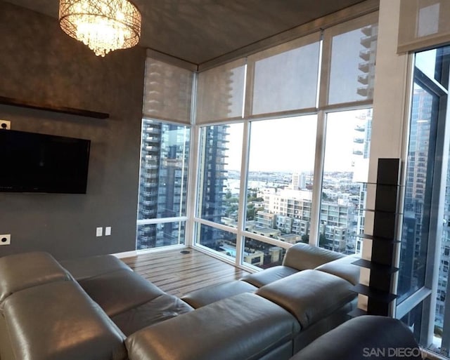 living room with wood-type flooring, floor to ceiling windows, and a notable chandelier