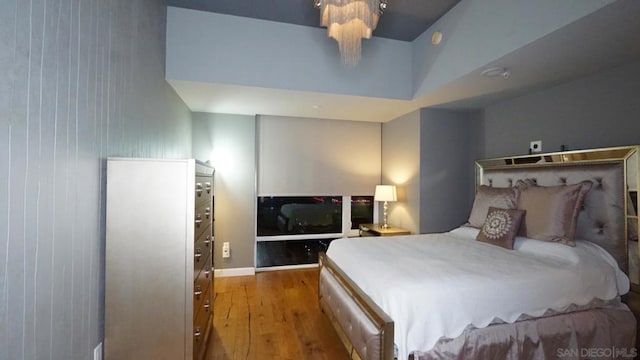 bedroom featuring a high ceiling and dark wood-type flooring