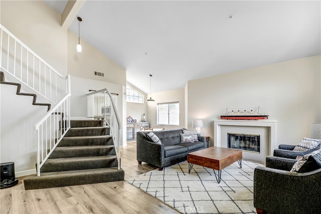 living room featuring light hardwood / wood-style floors and high vaulted ceiling