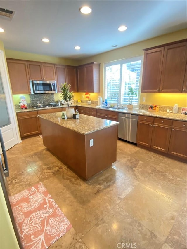 29161 Garnet Canyon Dr, Saugus, CA 91390 - kitchen with a center island, a sink, decorative backsplash, appliances with stainless steel finishes, and light stone countertops