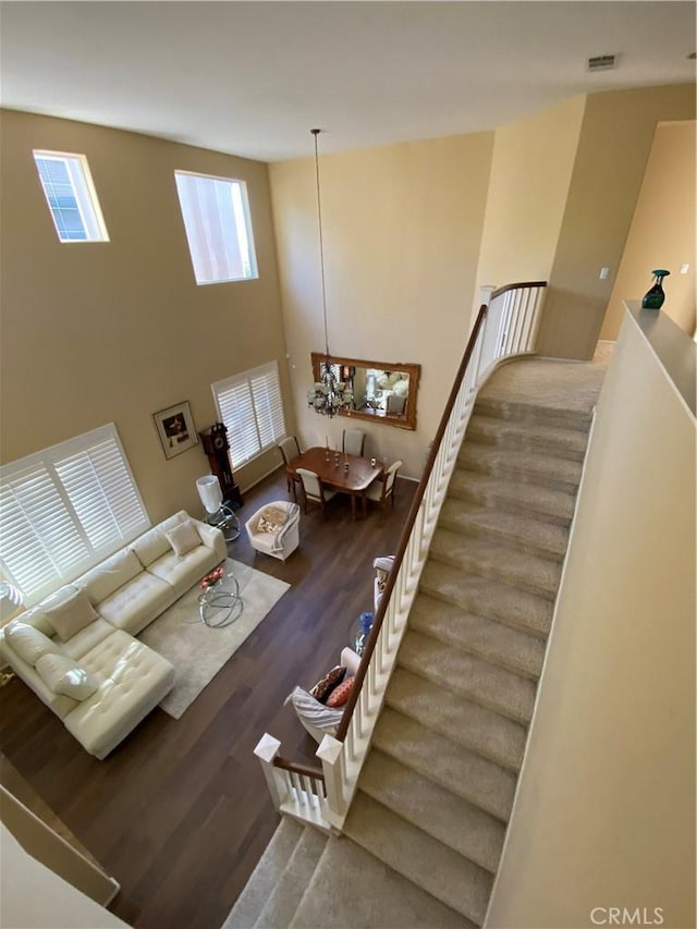 29161 Garnet Canyon Dr, Saugus, CA 91390 - living room featuring a towering ceiling, an inviting chandelier, wood finished floors, visible vents, and stairs