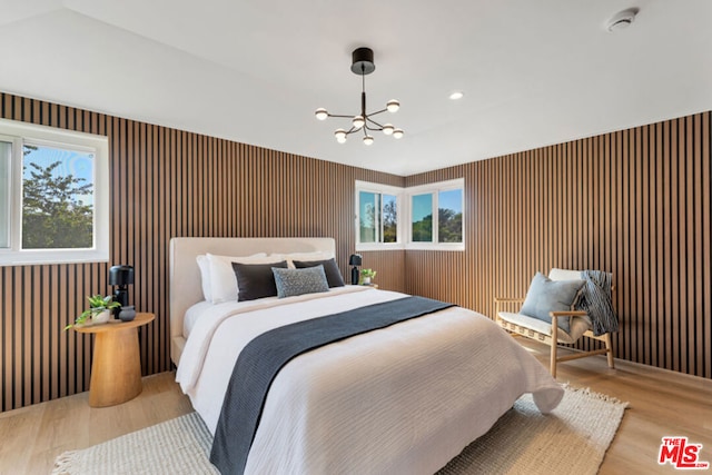 bedroom with light wood-type flooring and a chandelier