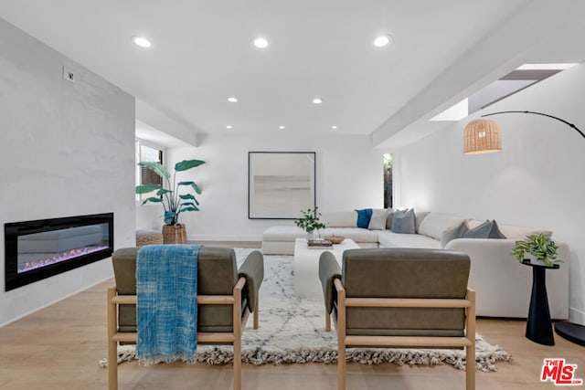 living room featuring a large fireplace and light hardwood / wood-style floors