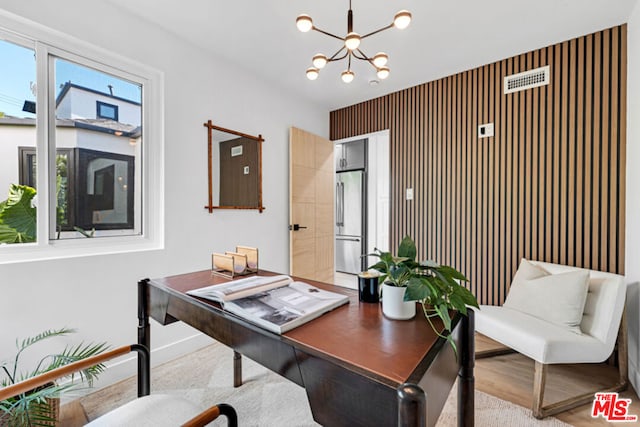 office space featuring light hardwood / wood-style floors and an inviting chandelier