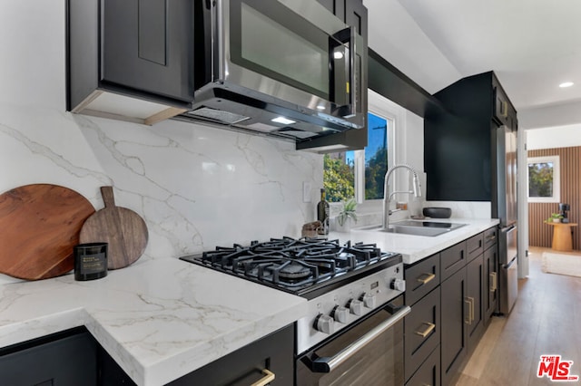 kitchen with a wealth of natural light, sink, stainless steel appliances, and light wood-type flooring