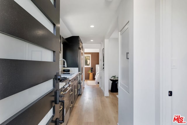 hall with light hardwood / wood-style flooring and sink