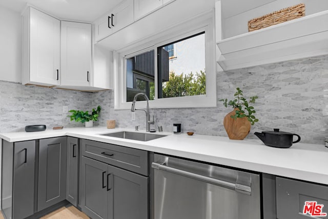 kitchen with decorative backsplash, sink, dishwasher, gray cabinets, and white cabinetry