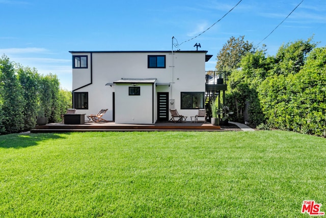 back of property featuring a yard and a deck