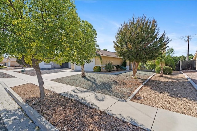 view of property hidden behind natural elements featuring a garage