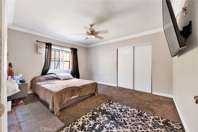 carpeted bedroom featuring ceiling fan, a closet, and crown molding