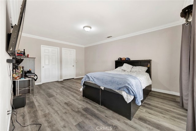 bedroom with hardwood / wood-style floors and crown molding