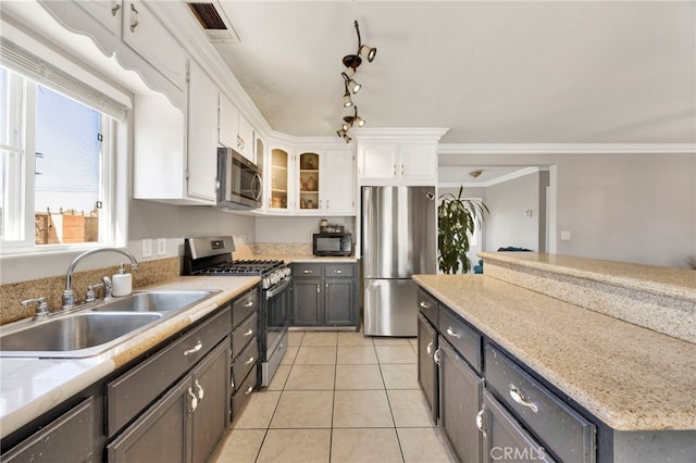 kitchen with white cabinets, sink, crown molding, and appliances with stainless steel finishes