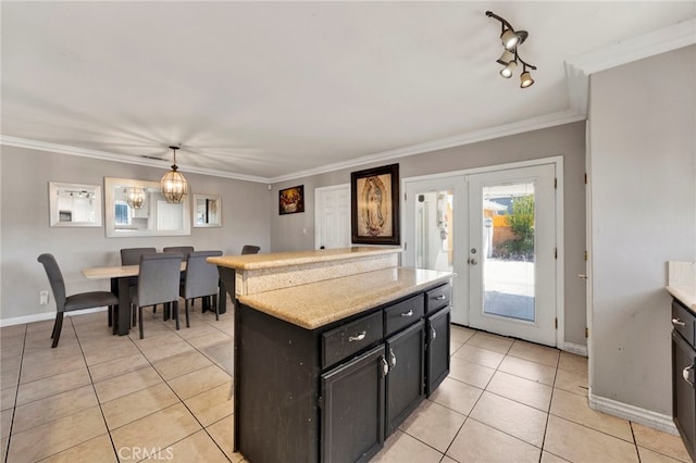 kitchen with french doors, light tile patterned floors, hanging light fixtures, and crown molding