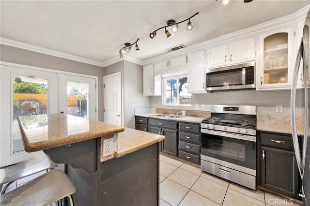 kitchen featuring stainless steel appliances, crown molding, sink, white cabinets, and a kitchen island