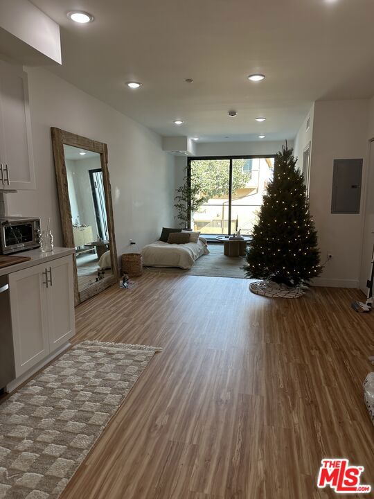 interior space with wood-type flooring and electric panel