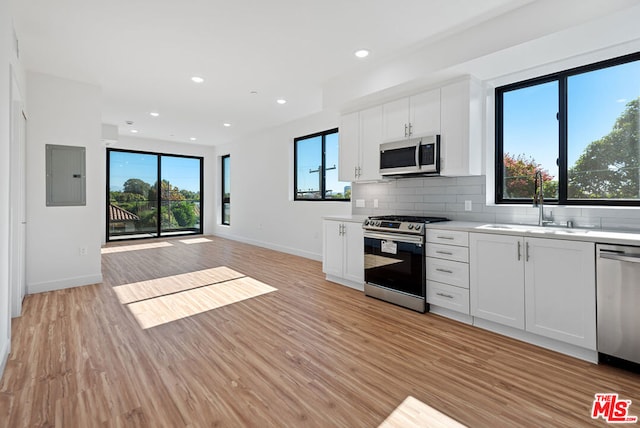 kitchen with plenty of natural light, white cabinetry, and appliances with stainless steel finishes