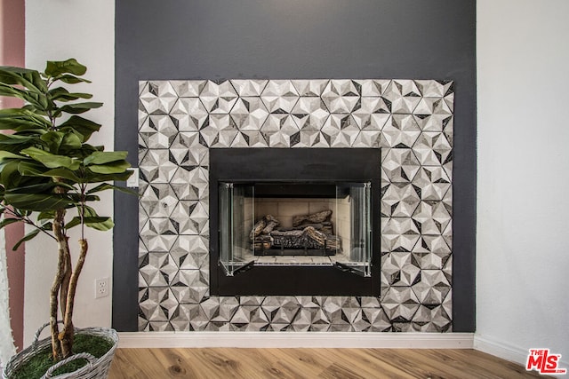 details featuring a tiled fireplace and wood-type flooring