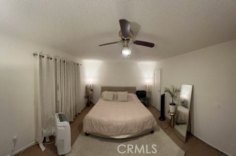 carpeted bedroom with a textured ceiling and ceiling fan