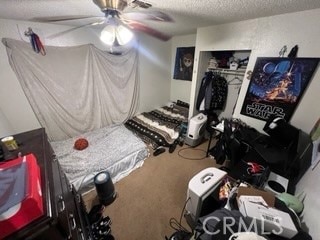 bedroom featuring a closet, a textured ceiling, carpet flooring, and ceiling fan