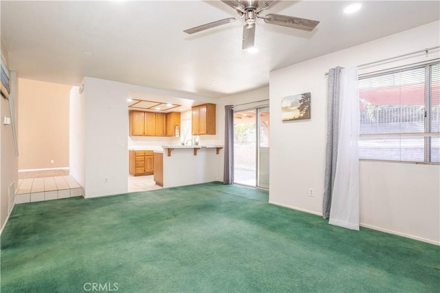 unfurnished living room with ceiling fan and light colored carpet