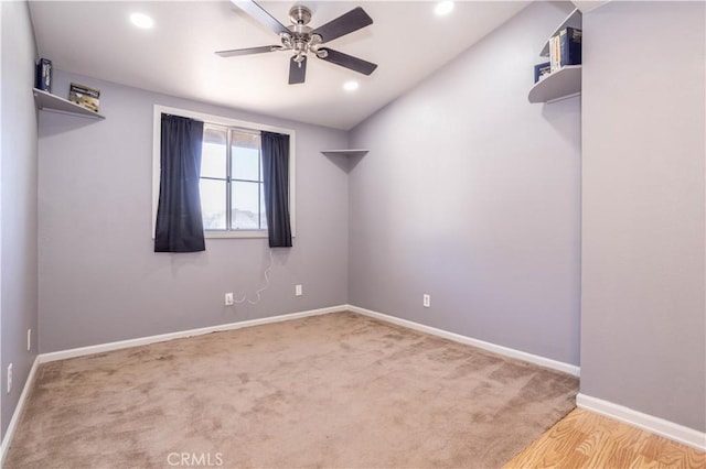 carpeted spare room featuring ceiling fan