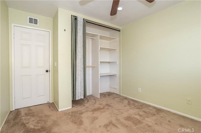 unfurnished bedroom featuring carpet flooring, a closet, and ceiling fan