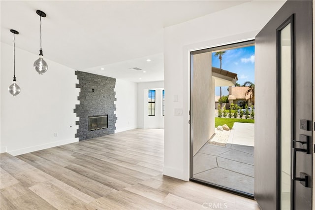 foyer featuring light hardwood / wood-style floors and a stone fireplace