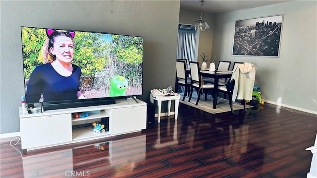 living room with hardwood / wood-style floors and a notable chandelier