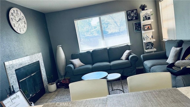 living room featuring a tile fireplace and light tile patterned floors