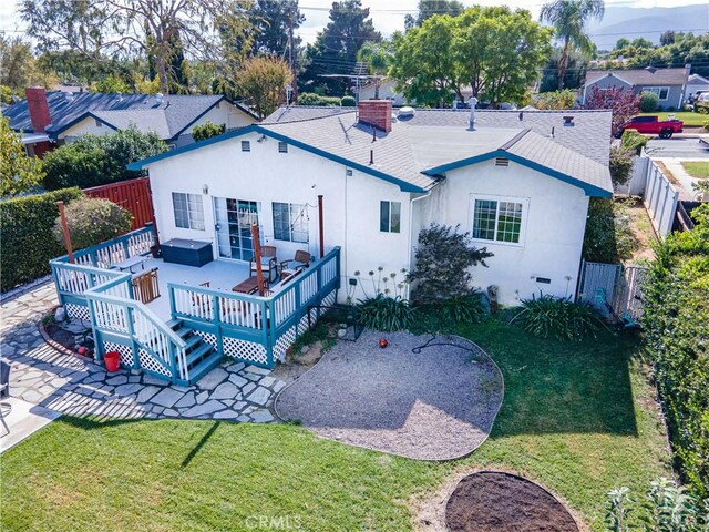 back of house featuring a wooden deck and a yard