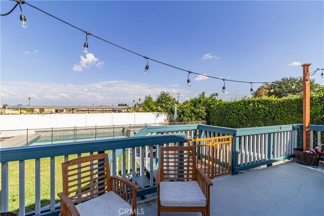 wooden deck with a fenced in pool