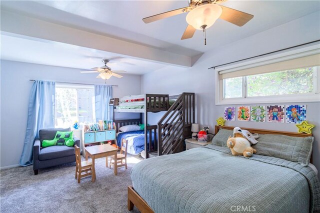 carpeted bedroom with beamed ceiling, multiple windows, and ceiling fan